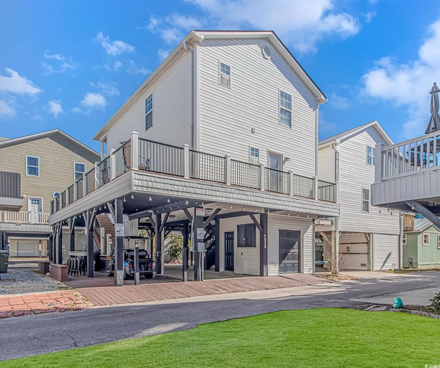 rear view of property featuring a garage, a lawn, and a carport