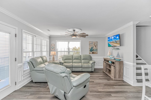 living room with ornamental molding, wood-type flooring, and ceiling fan