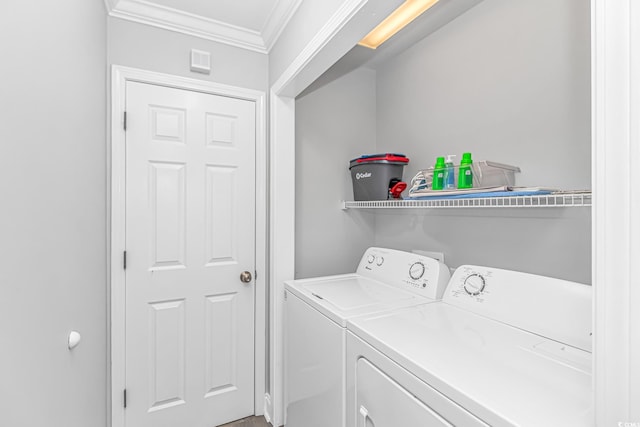 laundry area with crown molding and washer and clothes dryer