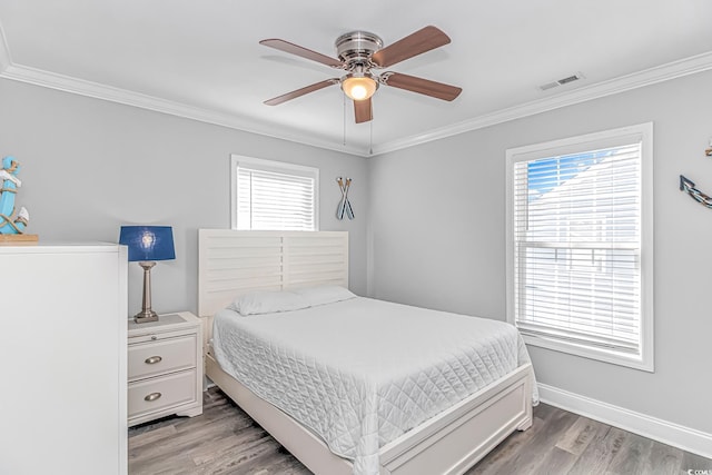 bedroom with crown molding, multiple windows, and hardwood / wood-style flooring