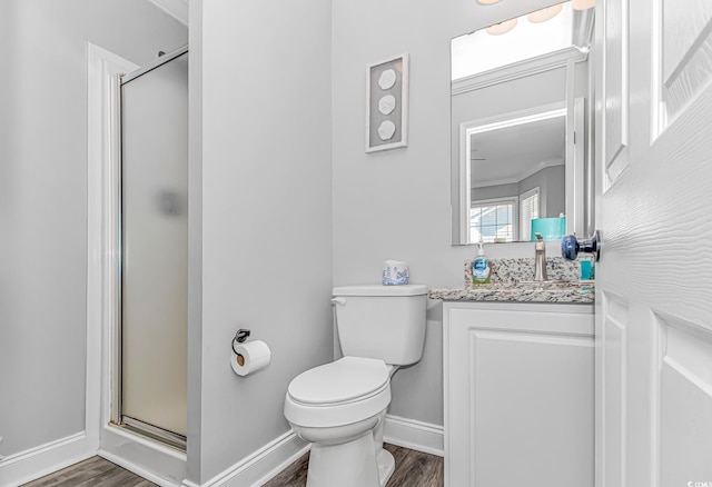 bathroom featuring hardwood / wood-style flooring, a shower with door, vanity, ornamental molding, and toilet