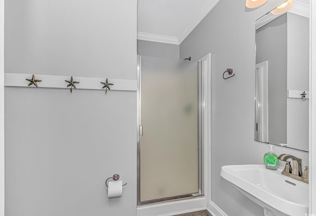 bathroom with ornamental molding, sink, and an enclosed shower