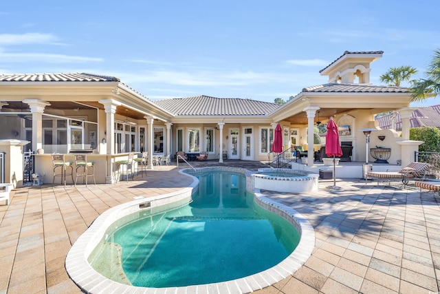 view of swimming pool with an in ground hot tub, a patio area, ceiling fan, and a bar