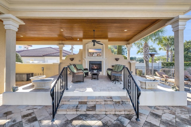 view of patio featuring ceiling fan and an outdoor fireplace