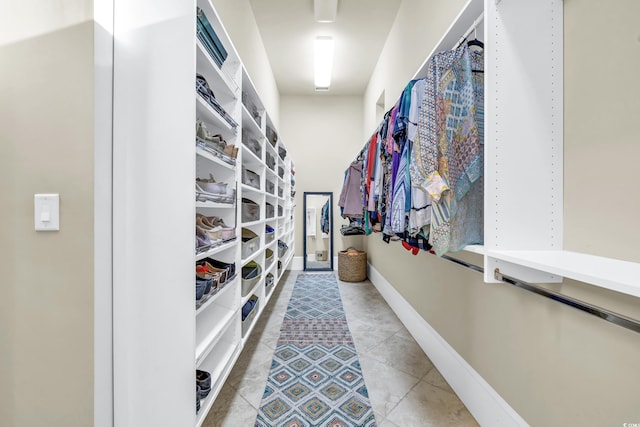 walk in closet with light tile patterned floors