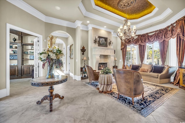 tiled living room with a tray ceiling, ornamental molding, and a chandelier