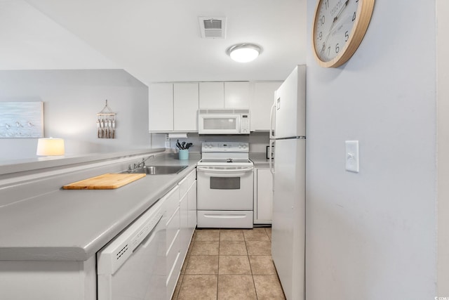 kitchen featuring sink, white appliances, light tile patterned floors, and white cabinets