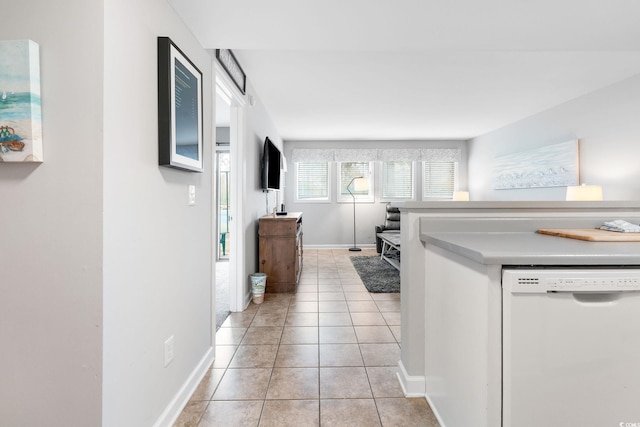 kitchen featuring light tile patterned flooring and white dishwasher