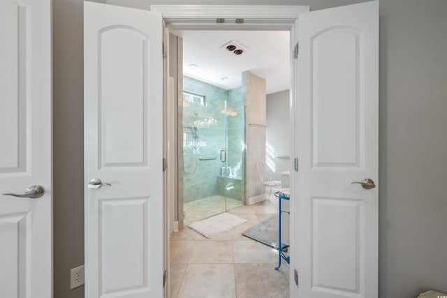 bathroom with a shower stall and tile patterned flooring