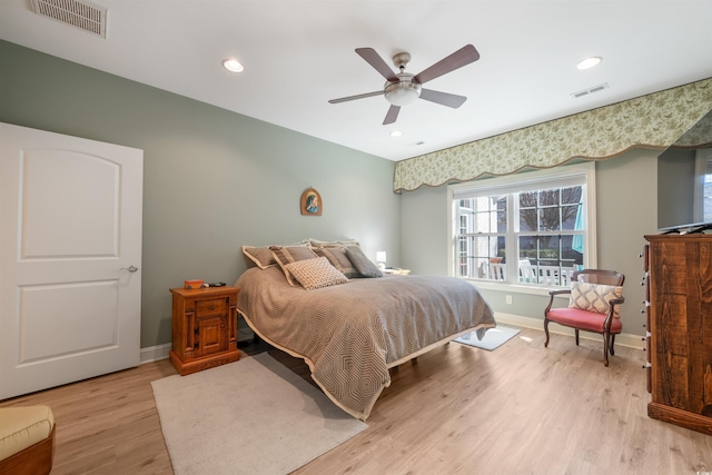 bedroom with light wood-style floors, multiple windows, and visible vents
