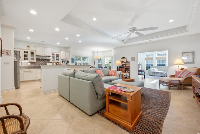 living room with a tray ceiling, recessed lighting, and light tile patterned floors