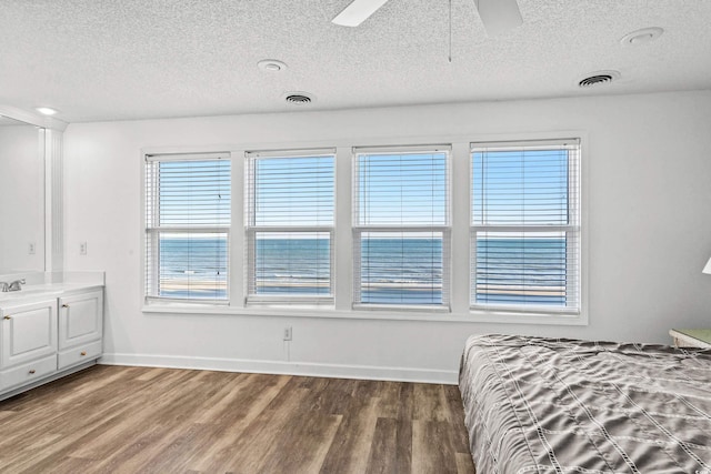 2022 N Waccamaw Dr, Garden City Beach, SC 29576 - bedroom featuring a textured ceiling, wood finished floors, baseboards, and a ceiling fan