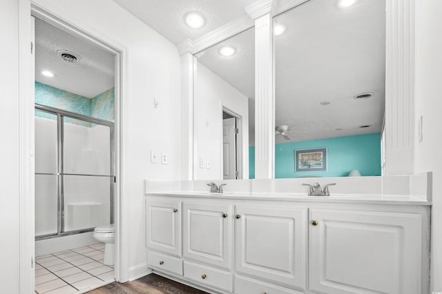 2022 N Waccamaw Dr, Garden City Beach, SC 29576 - bathroom with a stall shower, a textured ceiling, double vanity, toilet, and ceiling fan