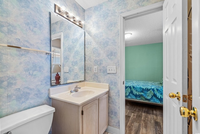 2022 N Waccamaw Dr, Garden City Beach, SC 29576 - bathroom featuring a textured ceiling, wood finished floors, toilet, wallpapered walls, and vanity