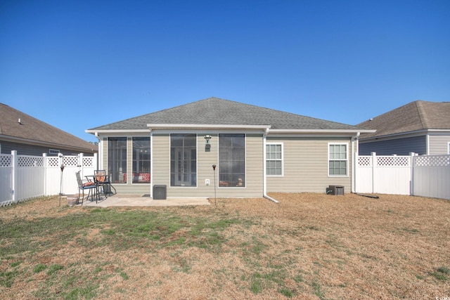 back of house featuring a patio area, a fenced backyard, a yard, and roof with shingles