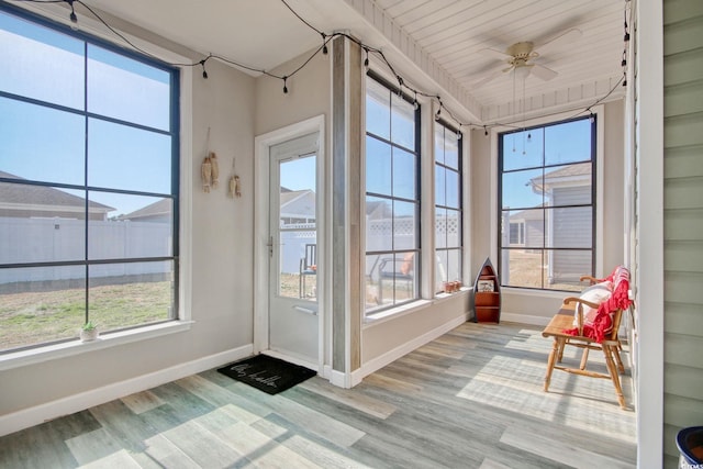 unfurnished sunroom with a ceiling fan