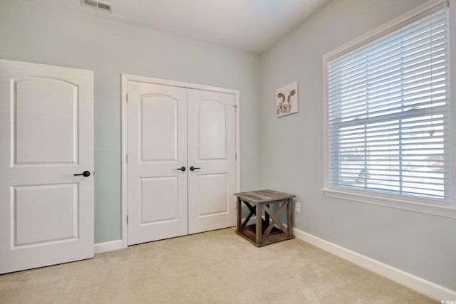 bedroom with carpet floors, visible vents, baseboards, and a closet