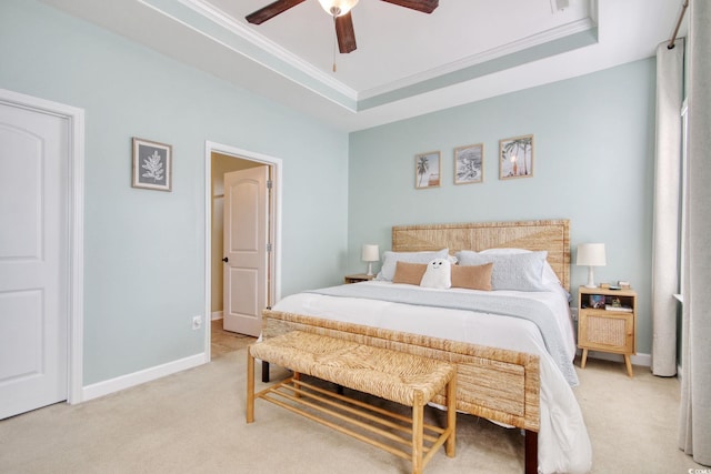 bedroom with baseboards, a raised ceiling, a ceiling fan, light colored carpet, and crown molding