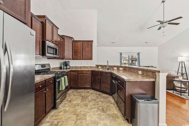 kitchen with sink, dark brown cabinets, kitchen peninsula, ceiling fan, and stainless steel appliances