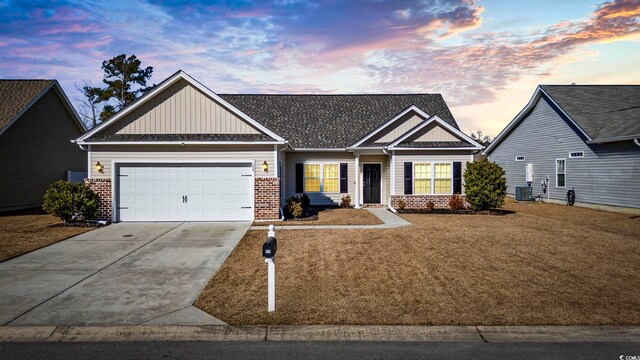 view of front of property with a garage, a yard, and cooling unit