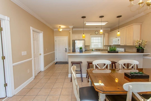 kitchen featuring pendant lighting, stainless steel fridge, a breakfast bar area, range, and light tile patterned flooring