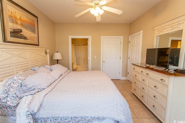 bedroom featuring ceiling fan, light tile patterned floors, and ensuite bath