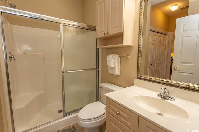 bathroom with an enclosed shower, vanity, and toilet