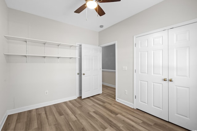 unfurnished bedroom with ceiling fan, light wood-type flooring, and a closet