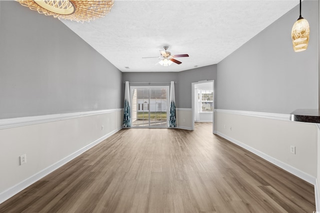 empty room featuring hardwood / wood-style flooring, ceiling fan, and a textured ceiling