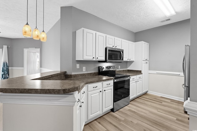 kitchen with stainless steel appliances, kitchen peninsula, hanging light fixtures, and white cabinets