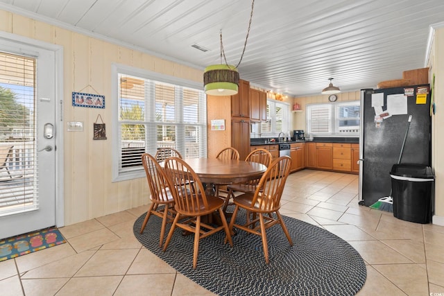 dining room with light tile patterned floors and crown molding