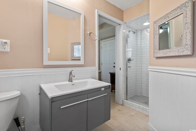 bathroom with an enclosed shower, vanity, hardwood / wood-style flooring, and toilet