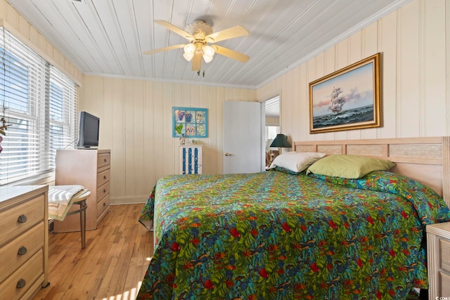 bedroom with crown molding, light hardwood / wood-style flooring, and ceiling fan