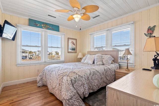 bedroom with multiple windows, light hardwood / wood-style flooring, ornamental molding, and ceiling fan