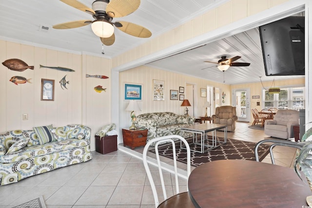 living room featuring light tile patterned flooring, ceiling fan, and crown molding