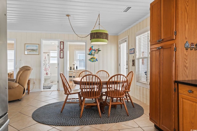 dining room featuring crown molding and light tile patterned floors