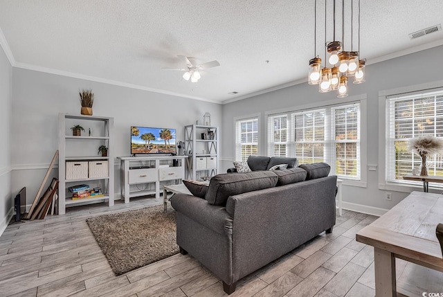 living room featuring crown molding, ceiling fan with notable chandelier, and a textured ceiling