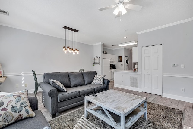 living room with crown molding, light hardwood / wood-style floors, and ceiling fan