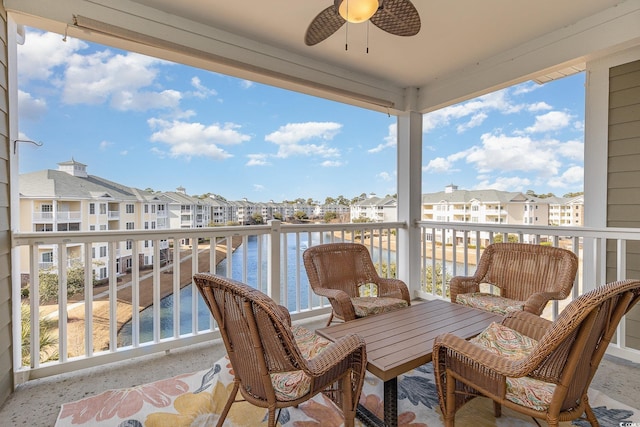 balcony featuring a water view and ceiling fan