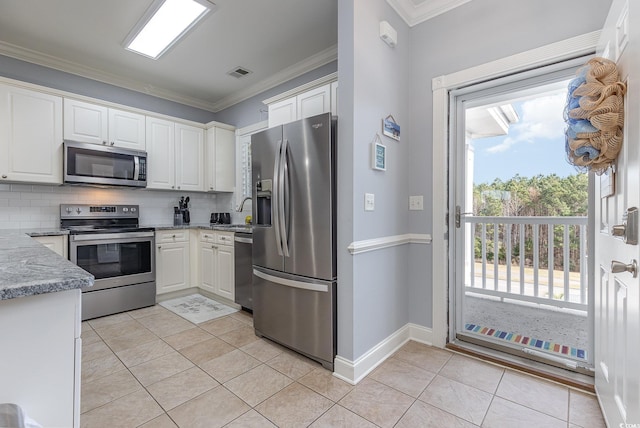 kitchen featuring white cabinetry, backsplash, light tile patterned floors, and stainless steel appliances