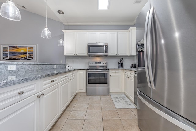 kitchen with pendant lighting, appliances with stainless steel finishes, light tile patterned floors, and white cabinets