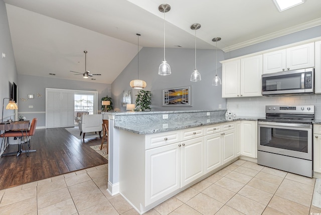 kitchen featuring decorative light fixtures, light tile patterned floors, kitchen peninsula, stainless steel appliances, and light stone countertops