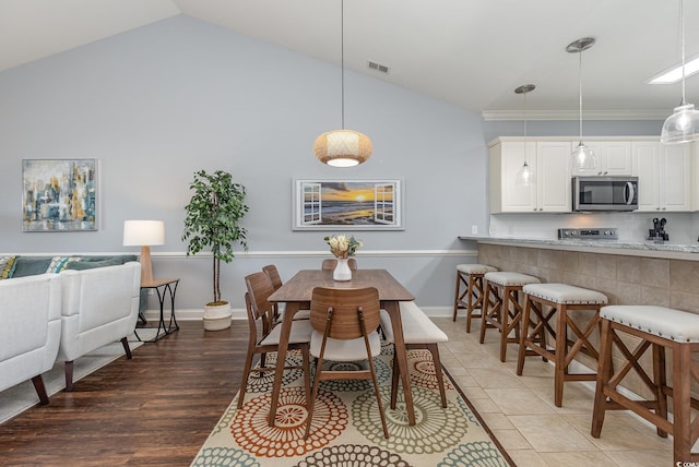 dining room with dark hardwood / wood-style flooring and vaulted ceiling