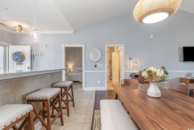 dining space with lofted ceiling and light tile patterned floors