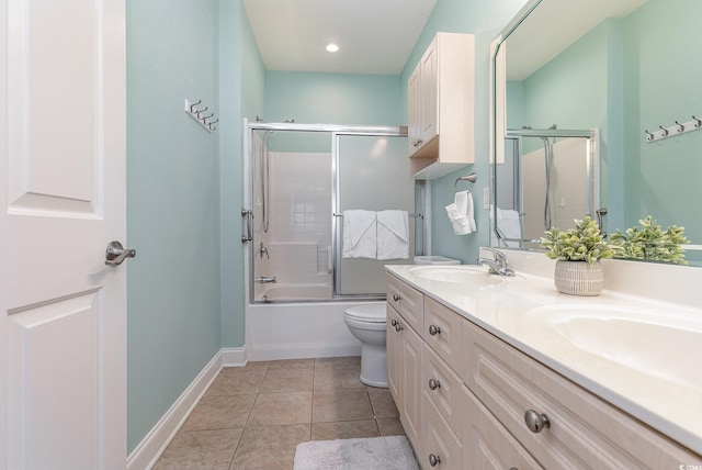 full bathroom featuring bath / shower combo with glass door, vanity, tile patterned floors, and toilet