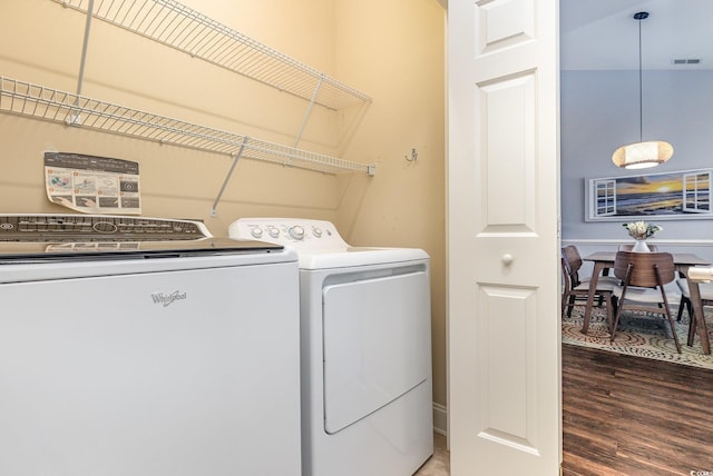 laundry room with independent washer and dryer and hardwood / wood-style floors