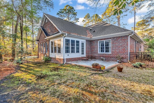 rear view of house featuring a patio and a lawn