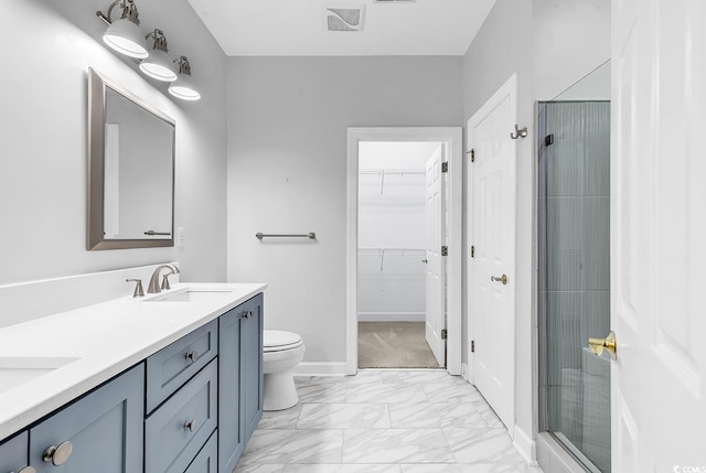 bathroom featuring double vanity, a stall shower, marble finish floor, a walk in closet, and a sink