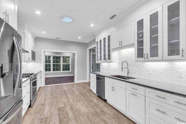 kitchen featuring appliances with stainless steel finishes, sink, white cabinets, and light hardwood / wood-style floors