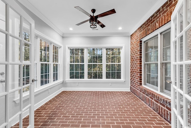 unfurnished sunroom with ceiling fan